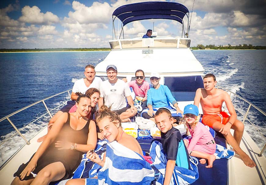 Group of people on a boat in the water with a scenic background
