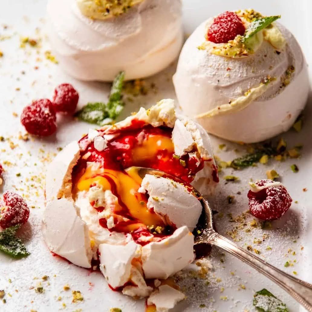 Meringue dessert with fruit and a spoon on a light background