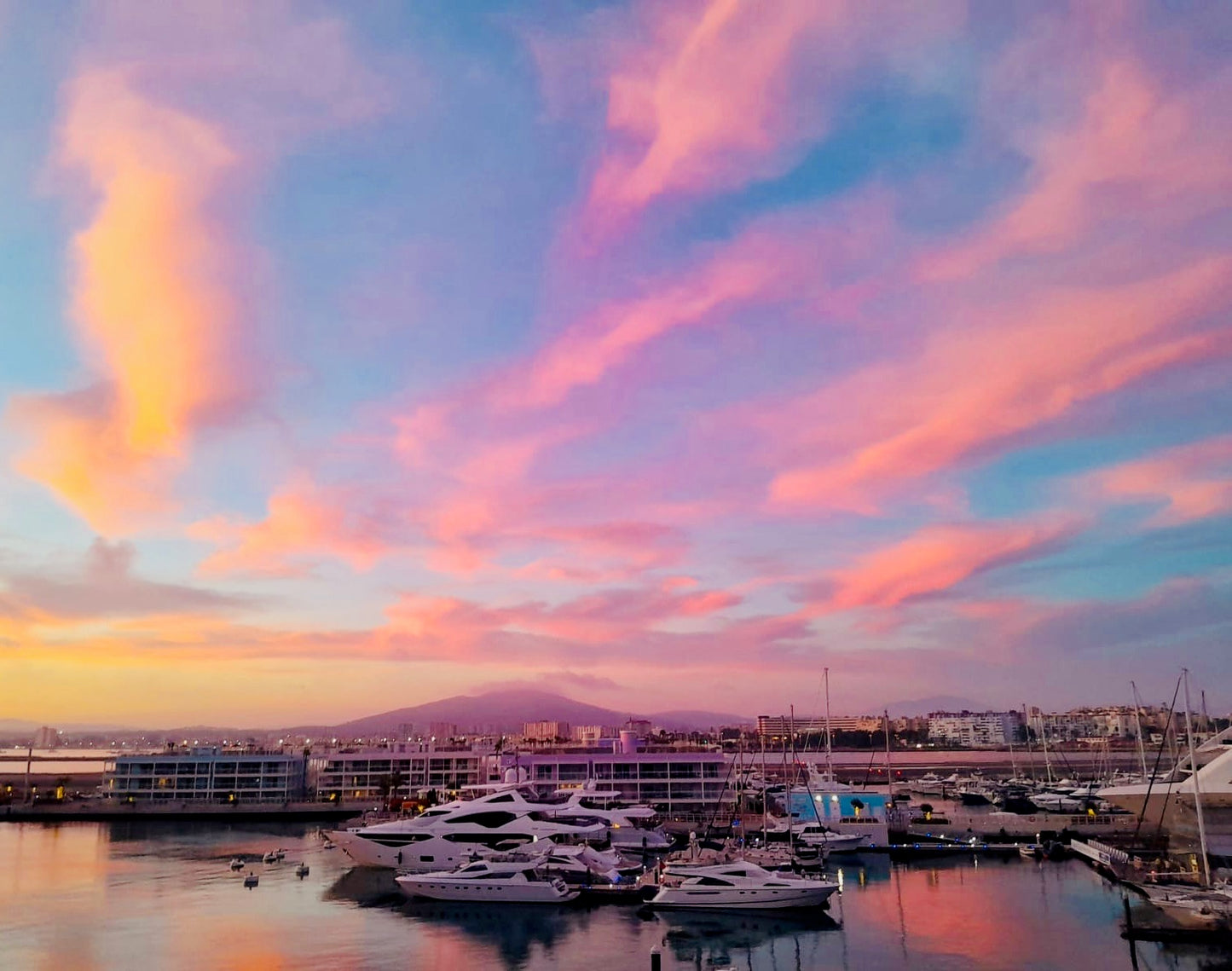 Marina with boats under a colorful sunset sky