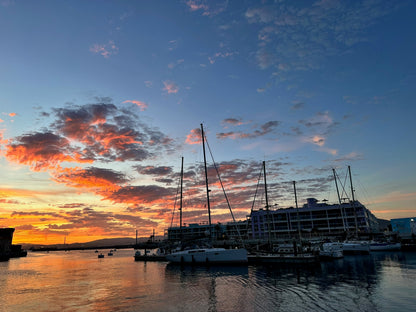Marina in Gibraltar with boats at sunset under a colorful sky