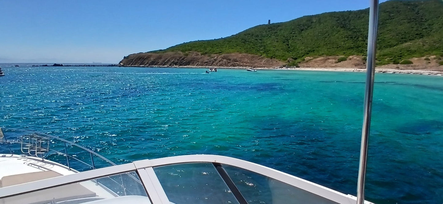Boat on a clear blue sea with a Gibraltar mountainous island in the background