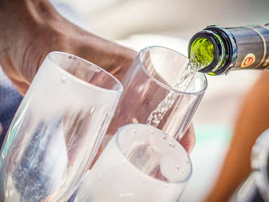 Wine being poured into two glasses with a blurred background