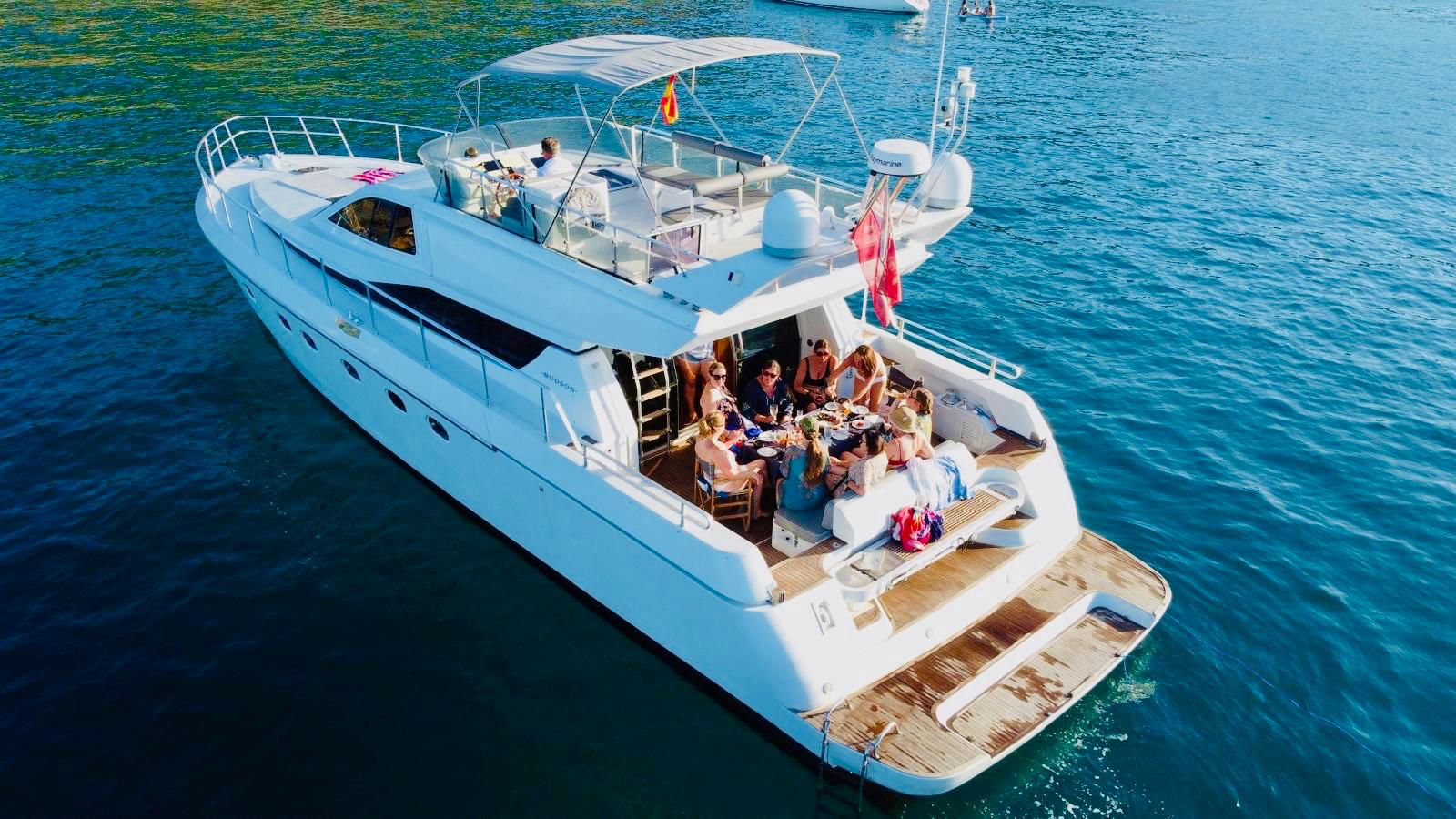 Yacht on the water with people enjoying a meal.