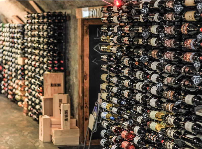 Wine bottles stacked on shelves in a wine cellar